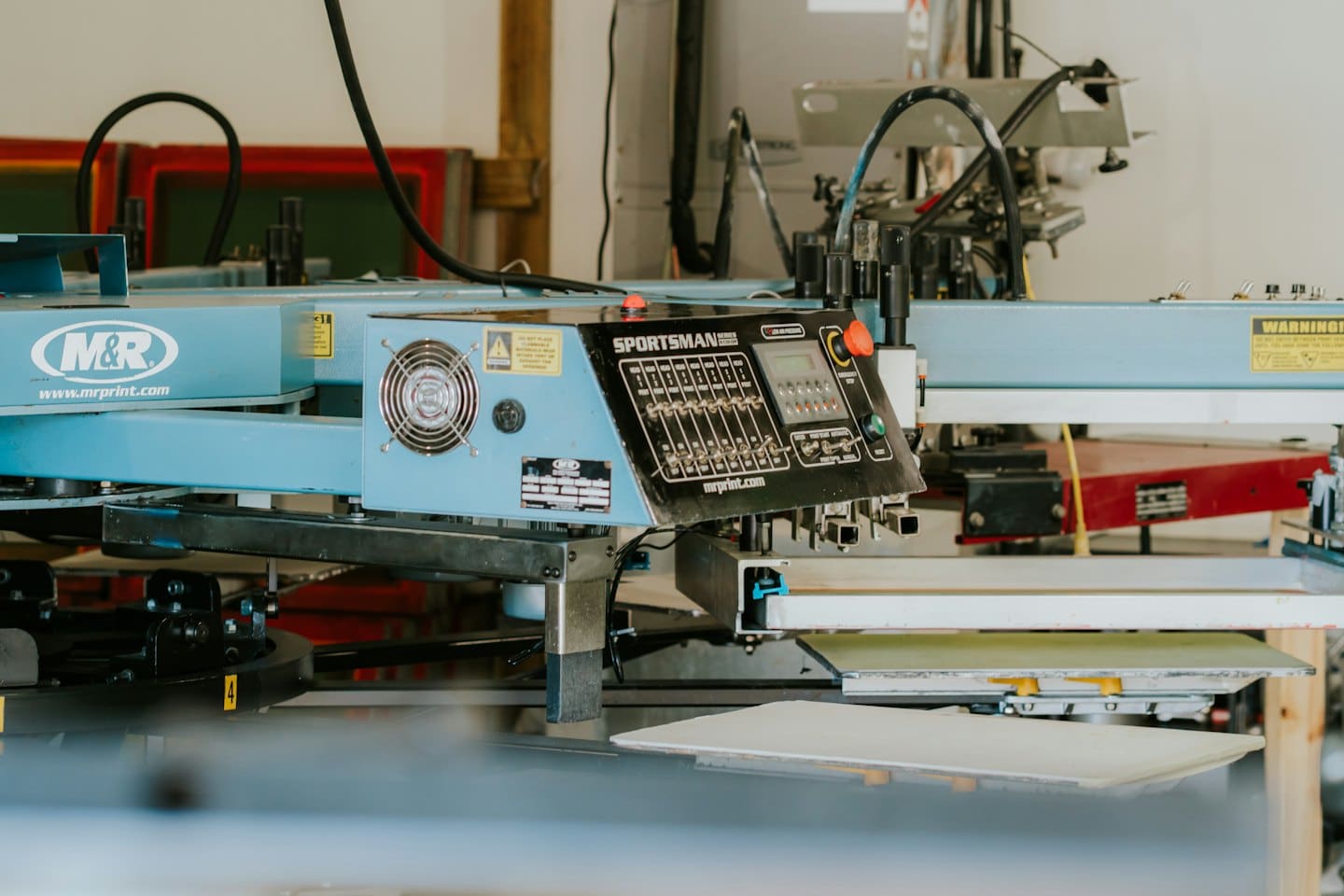 Automated screen printing machine control panel in a workshop.