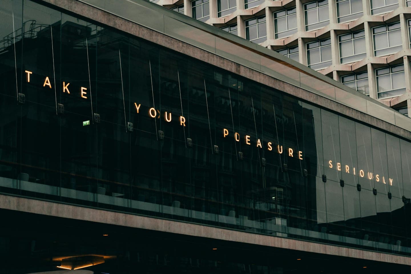Illuminated amber text displays on the dark glass facade.